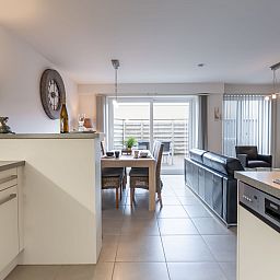 Modern living room and kitchen in Apartment Residentie Zandloper, Bredene, Belgian coast, with spacious sitting area and dining table.