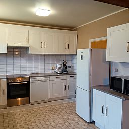 Moderne keuken in Vakantiehuis Ruiterlaan, Bredene, Belgische kust. Gezellige ruimte met witte kasten en moderne apparatuur.