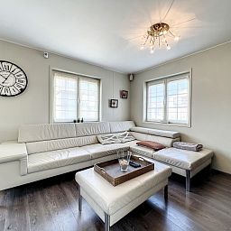 Stijlvolle woonkamer in Red Sea vakantiehuis te Middelkerke met comfortabele zithoek en veel natuurlijk licht.