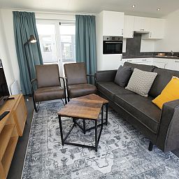 Gezellige woonkamer in Premium Lodge I voor 6 personen, vakantiehuis in Nieuwpoort, Belgische kust, met moderne keuken en comfortabele zithoek.