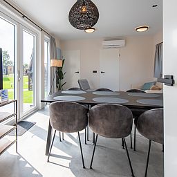 Stijlvolle binnenruimte van Wood Lodge in Nieuwpoort, Belgische kust. Moderne keuken en eetgedeelte in vakantiehuis voor 6 personen met airco.