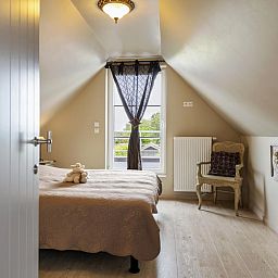 Knusse slaapkamer in Rust achter de Kust, een vakantiehuis in Nieuwpoort aan de Belgische kust, met uitzicht op de tuin.