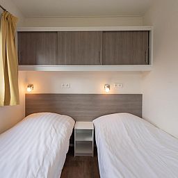 Slaapkamer in Comfort Lodge, Nieuwpoort: knusse ruimte met twee bedden en moderne inrichting, ideaal voor een ontspannen verblijf aan de Belgische kust.