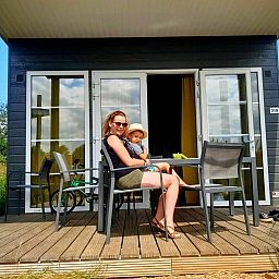 Geniet van de zon op de veranda van Comfort Lodge, een vakantiehuis in Nieuwpoort aan de Belgische kust, ideaal voor een ontspannen verblijf.