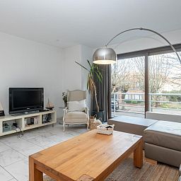 Moderne woonkamer van vakantiehuis Reigersnest in Nieuwpoort, Belgische kust, met stijlvolle inrichting en ruime open keuken.