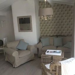 Gemuetliche Sitzecke im "Het Toeval", einem Ferienhaus in Oostduinkerke an der belgischen Kueste, mit bequemen Sofas und einer entspannten Atmosphaere.