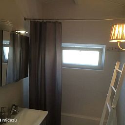 Modernes Badezimmer im Ferienhaus "Het Toeval" in Oostduinkerke an der belgischen Kueste mit stimmungsvoller Beleuchtung und praktischen Ausstattungsmerkmalen.