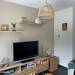 Gemuetliches Wohnzimmer im Ferienhaus "Witte Oase" in Oostduinkerke an der belgischen Kueste mit moderner Einrichtung und stimmungsvollen Dekorationen.