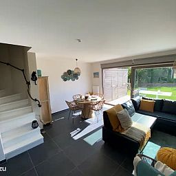 Gemuetliches Wohnzimmer des Ferienhauses "Witte Oase" in Oostduinkerke an der belgischen Kueste, mit moderner Einrichtung und Blick auf den Garten.