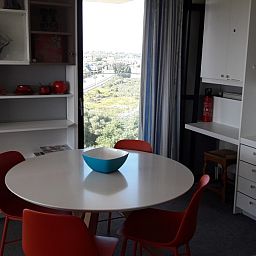 Gezellige eetruimte in appartement Nieuwpoort-Bad, Belgische kust, met uitzicht op de omgeving, ideaal voor een ontspannen vakantie.