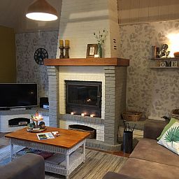 Gemuetliches Schlafzimmer im Ferienhaus Windekind mit bequemem Sofa und stimmungsvoller Beleuchtung, gelegen in De Panne an der belgischen Kueste.