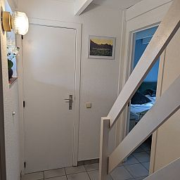 Eingang zum Ferienhaus Duinendaele II in De Panne, belgische Kueste, mit moderner Einrichtung und Zugang zu den Schlafzimmern.