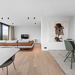 Luxury living room of Penthouse 'Ter Elst' in De Panne, Belgian coast, with panoramic views and modern furnishings for ultimate comfort.