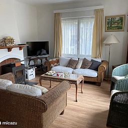 Gemuetliches Wohnzimmer im Ferienhaus "Quiet Corner" in De Panne an der belgischen Kueste, mit einer bequemen Sitzecke und rustikaler Einrichtung.