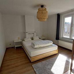 Gemuetliches Schlafzimmer im Ferienhaus "De Zji" in De Panne an der belgischen Kueste, mit grossem Fenster und moderner Einrichtung fuer einen entspannten Aufenthalt.