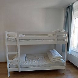 Gemuetliches Schlafzimmer im Ferienhaus "De Zji" in De Panne an der belgischen Kueste, mit Etagenbett und Tageslicht durch grosse Fenster.