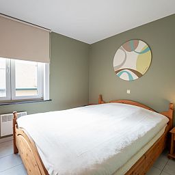Sfeervolle slaapkamer in Appartement Flipper nabij het strand in De Haan, Belgische kust. Comfortabel verblijf met rustgevende inrichting.