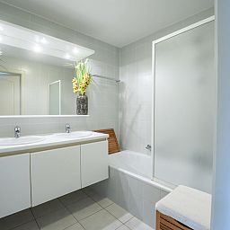 Moderne badkamer van Appartement Flipper nearby the beach in De Haan, Belgische kust, met dubbele wastafel en ruime douche.