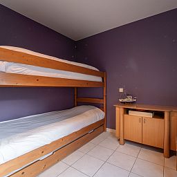 Gezellige slaapkamer in Appartement Flipper nabij het strand in De Haan, Belgische kust, met stapelbed en houten meubels.