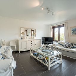Stijlvolle woonkamer in Vakantiehuis Ingrid met parkeergelegenheid, gelegen in De Haan aan de Belgische kust, ideaal voor ontspanning.