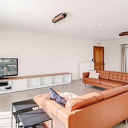 Ruime woonkamer met comfortabele zitplaatsen in Hoeve Langhof vakantiehuis, De Haan, Belgie.