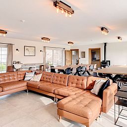 Open leefruimte in Hoeve Langhof vakantiehuis, De Haan, met veel licht en gezellige zithoek.