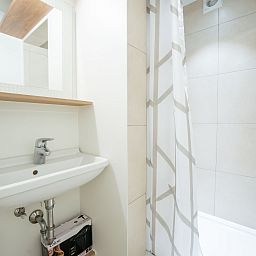 Moderne badkamer in Appartement Koekoeksnest Penthouse at the beach, De Haan, Belgische kust. Stijlvolle inrichting met douche en wastafel.