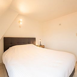 Comfortabele slaapkamer in Appartement Koekoeksnest Penthouse at the beach, De Haan, Belgische kust, ideaal voor ontspanning aan zee.