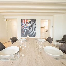 Stijlvolle eetkamer in Appartement Koekoeksnest Penthouse at the beach, De Haan, Belgische kust, met modern interieur en kunstzinnige decoratie.