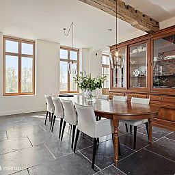 Elegante eetkamer in Huis Potaerde, een vakantiehuis in Brussel, Belgie, met veel natuurlijk licht en stijlvolle inrichting.