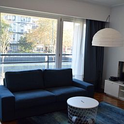 Gezellige woonkamer in Appartement in Woluwe-Saint-Lambert, Brussel met uitzicht op de stad, comfortabele bank en moderne inrichting.