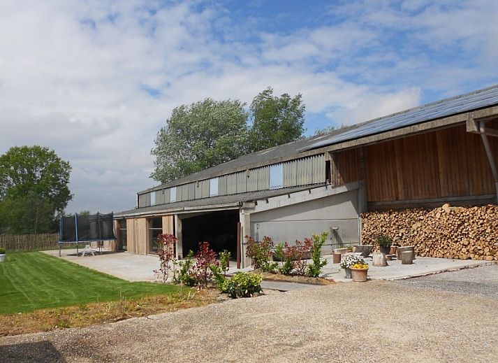 Aussenansicht des Ferienhauses Hof ter Harte, Ypern, Westflandern, mit roten Akzenten und bluehenden Hortensien.