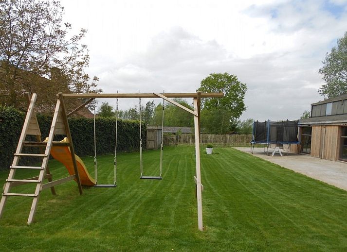 Aussenansicht des Ferienhauses Hof ter Harte, Ypern, Westflandern, mit roten Akzenten und bluehenden Hortensien.