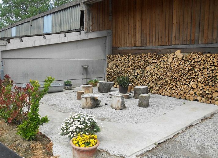 Aussenansicht des Ferienhauses Hof ter Harte, Ypern, Westflandern, mit roten Akzenten und bluehenden Hortensien.