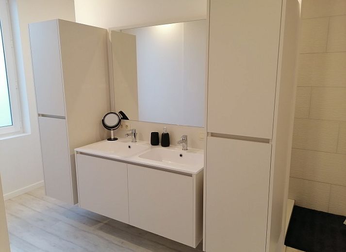 Gemuetliche Sitzecke in THE FRONT DOOR N28, Ferienhaus in Ypern, Westflandern, mit Ledersofas und stilvollen Tischen.