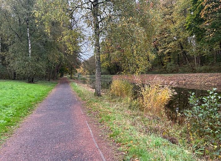Gemuetliche Leseecke im Ferienhaus in Ypern, Westflandern, mit bequemem Sessel und Blick auf die Natur durch eine grosse Glastuer.