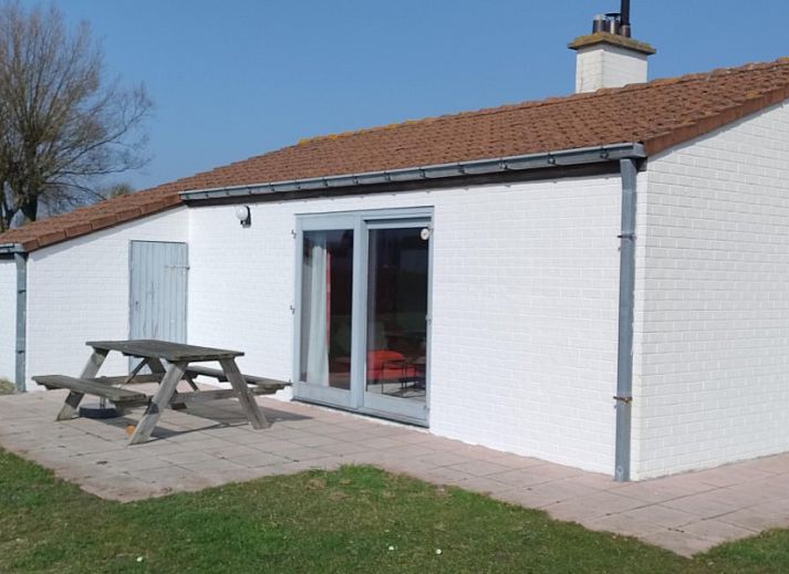 Veranda des Ferienhauses De Lombarde in Middelkerke, Belgien, mit gruener Umgebung und Wasserfront.