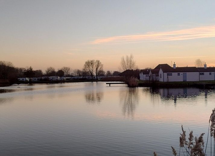 Veranda des Ferienhauses De Lombarde in Middelkerke, Belgien, mit gruener Umgebung und Wasserfront.