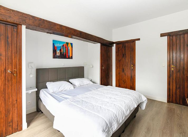 Gezellige slaapkamer in vakantiehuis Floribert, Nieuwpoort-Bad, met comfortabel tweepersoonsbed en rustgevend uitzicht op de tuin.