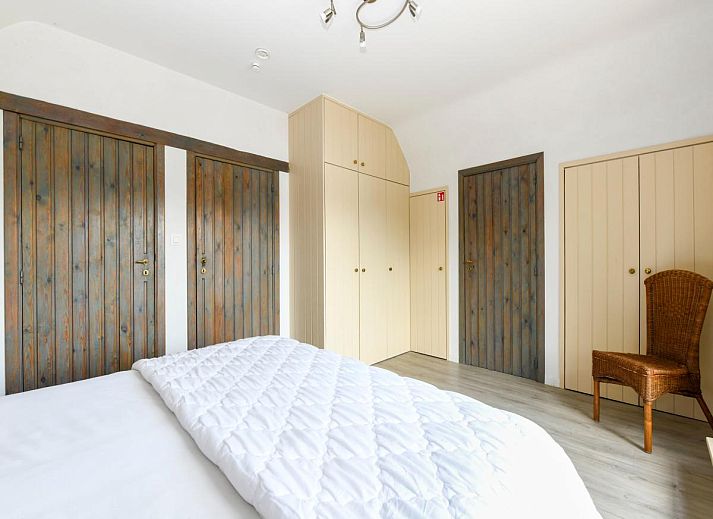 Gezellige slaapkamer in vakantiehuis Floribert, Nieuwpoort-Bad, met comfortabel tweepersoonsbed en rustgevend uitzicht op de tuin.