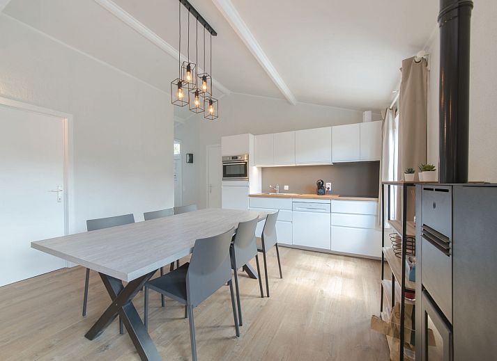 Helles Wohnzimmer des Ferienhauses Duinenhuisje 25 in De Haan, Westflandern, mit modernen Moebeln und geraeumigem Esszimmer.