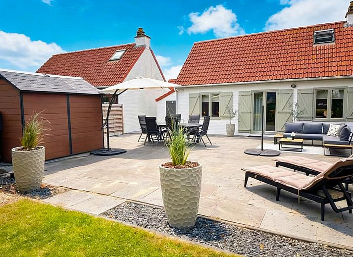 Geraeumige Terrasse der Villa Belle Haan in De Haan, Belgien, mit bequemen Sitzgelegenheiten und Sonnenschirmen fuer ein entspannendes Ferienerlebnis.