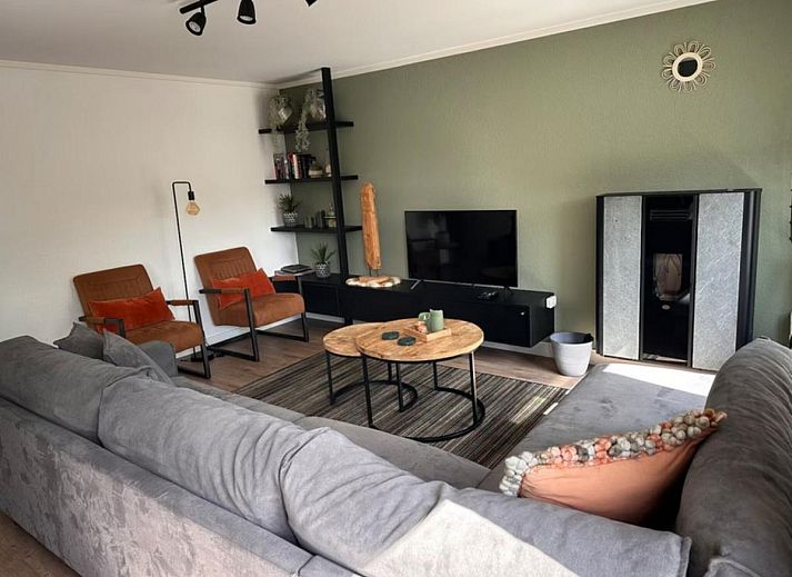 Geraeumige Terrasse der Villa Belle Haan in De Haan, Belgien, mit bequemen Sitzgelegenheiten und Sonnenschirmen fuer ein entspannendes Ferienerlebnis.