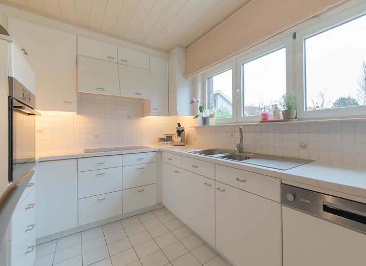 Gemuetliches Wohnzimmer des Ferienhauses Villa Kievit in De Haan, Westflandern, mit bequemer Sitzecke und viel Tageslicht.