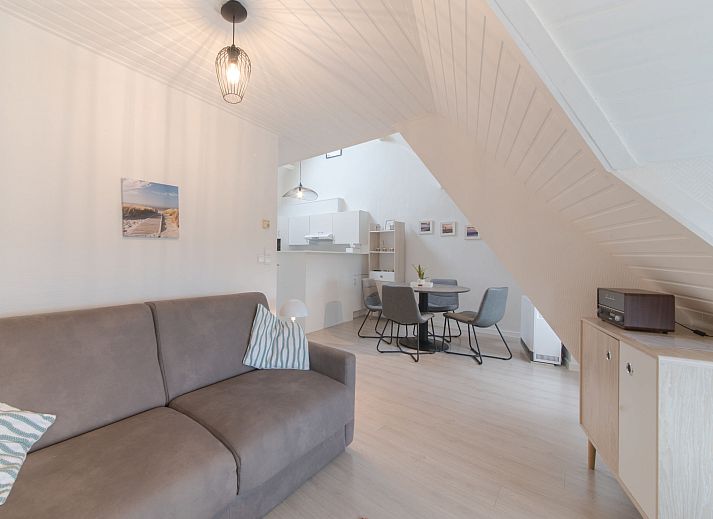 Gezellige zithoek in Appartement Carnac View, een topappartement in De Haan, West-Vlaanderen, met comfortabele bank en moderne inrichting.