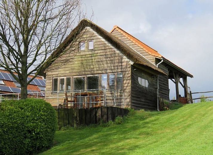 Gemuetliches Ferienhaus in Dranouter, Westflandern, mit Holzfassade und sonniger Terrasse, umgeben von gruener Natur.