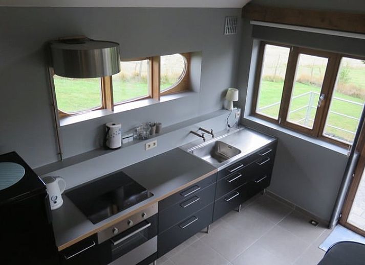 Gemuetliches Ferienhaus in Dranouter, Westflandern, mit Holzfassade und sonniger Terrasse, umgeben von gruener Natur.