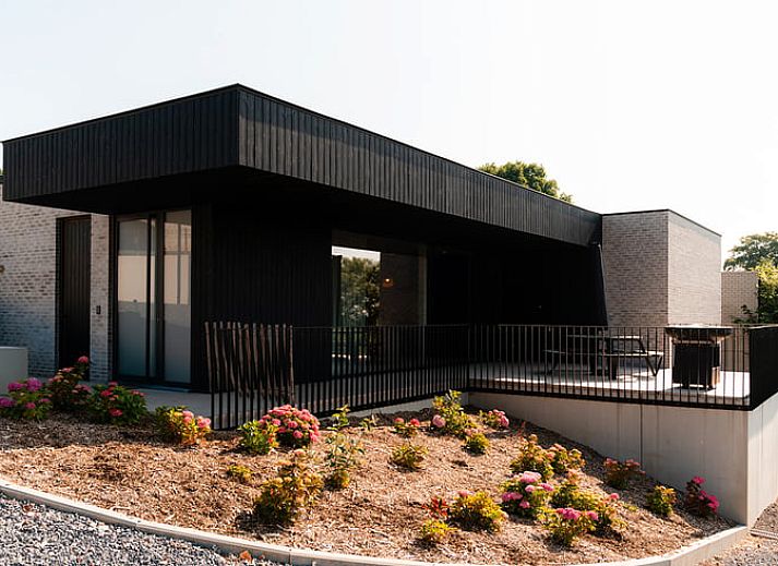 Geraeumige Terrasse des Ferienhauses in Westouter, Westflandern, mit Blick auf die gruene Umgebung und moderne Architektur.