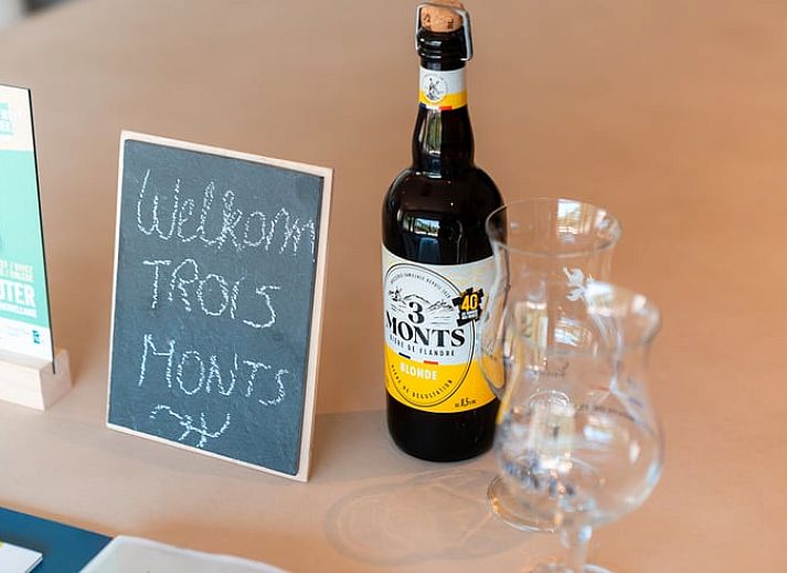 Ferienhaus in Westouter, Westflandern, Belgien, mit einer charmanten Backsteinmauer und einem Schild fuer einen einladenden Aufenthalt.