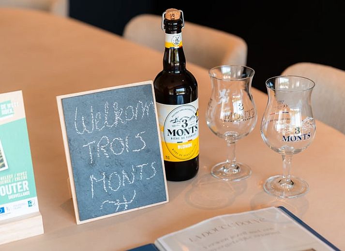 Ferienhaus in Westouter, Westflandern, Belgien, mit einer charmanten Backsteinmauer und einem Schild fuer einen einladenden Aufenthalt.